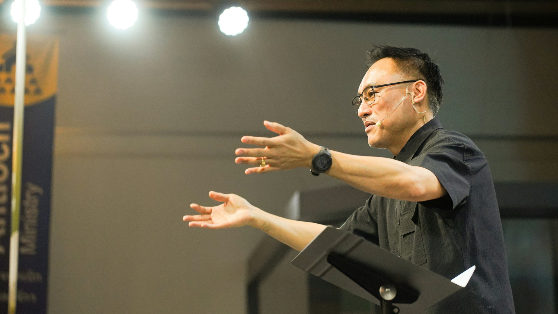 A microphone on a stand with a softly blurred audience in the background