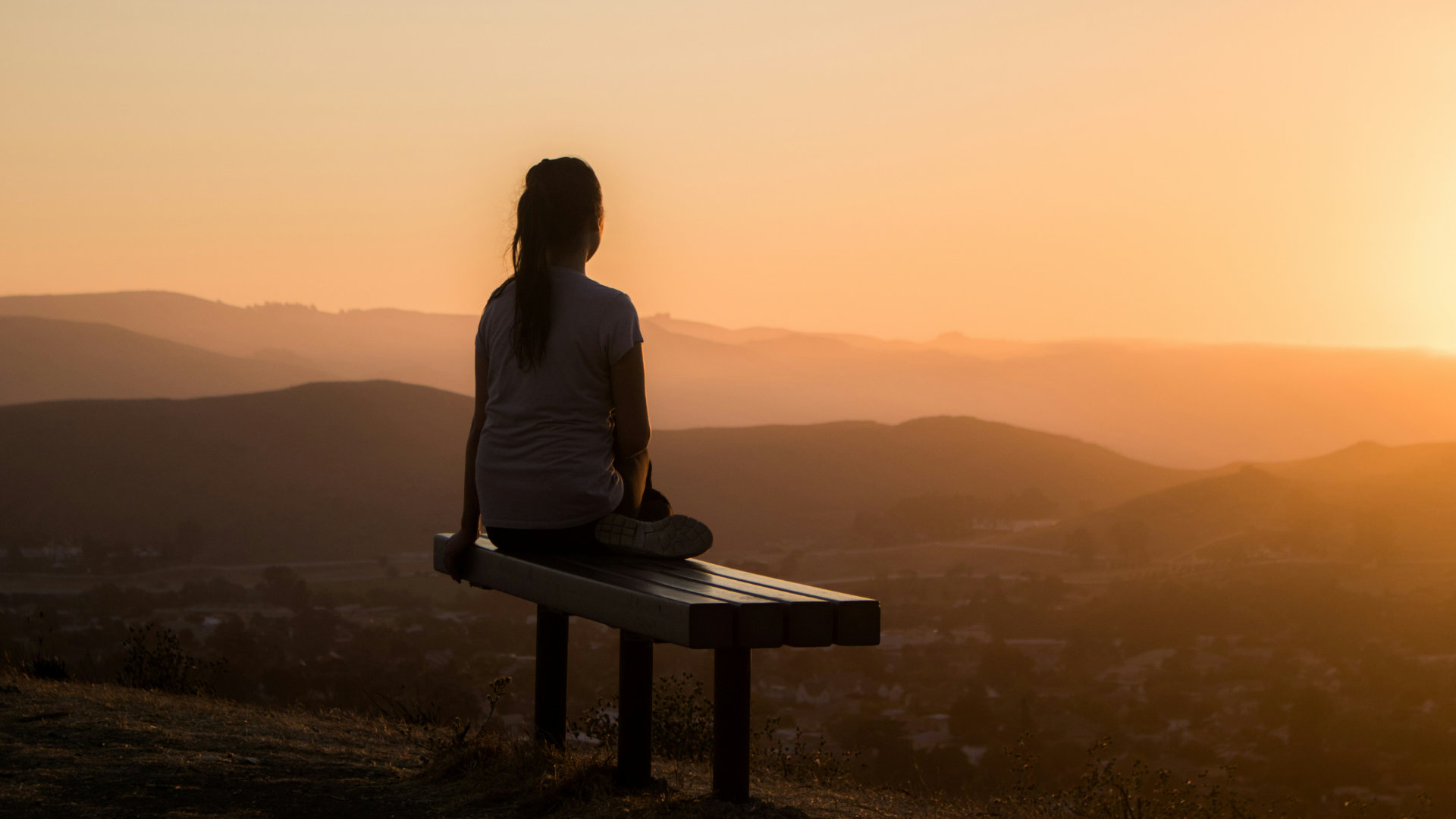 A person sitting quietly in soft natural light, looking calm and reflective